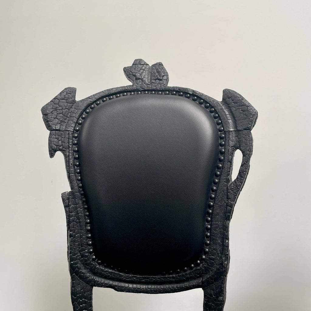 A set of seven Moooi Smoke Dining Side Chairs, crafted by Moooi in an ornate black finish with leather upholstery and cushioned seats and backs, arranged in two rows against a plain white background.