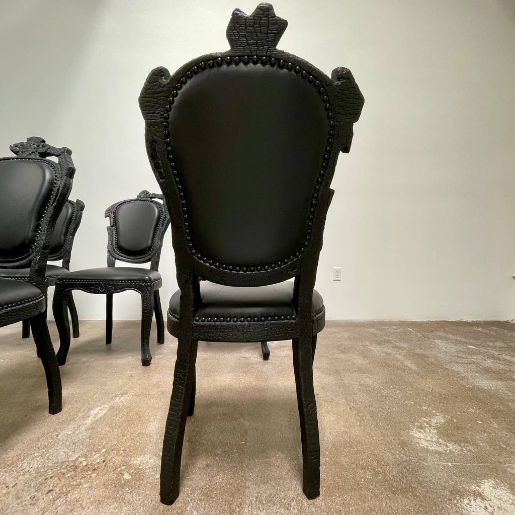 A set of seven Moooi Smoke Dining Side Chairs, crafted by Moooi in an ornate black finish with leather upholstery and cushioned seats and backs, arranged in two rows against a plain white background.