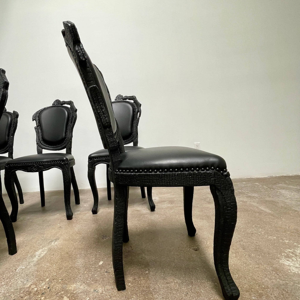 A set of seven Moooi Smoke Dining Side Chairs, crafted by Moooi in an ornate black finish with leather upholstery and cushioned seats and backs, arranged in two rows against a plain white background.