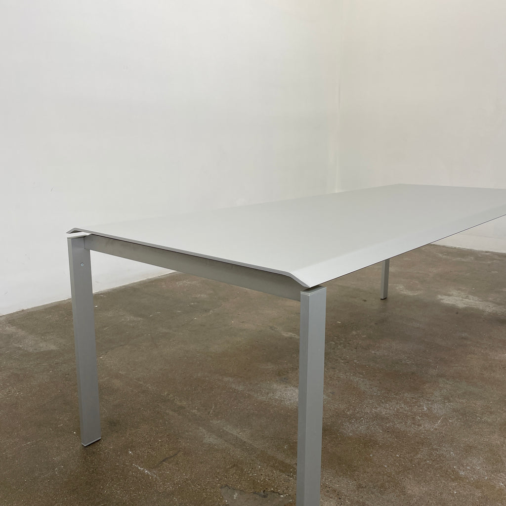 The Pallucco Italia Little Wing Dining Table, crafted with the elegance of Italian manufacturing and the design genius of Carlo Tamborini, boasts a minimalist white rectangular surface paired with slender metal legs.