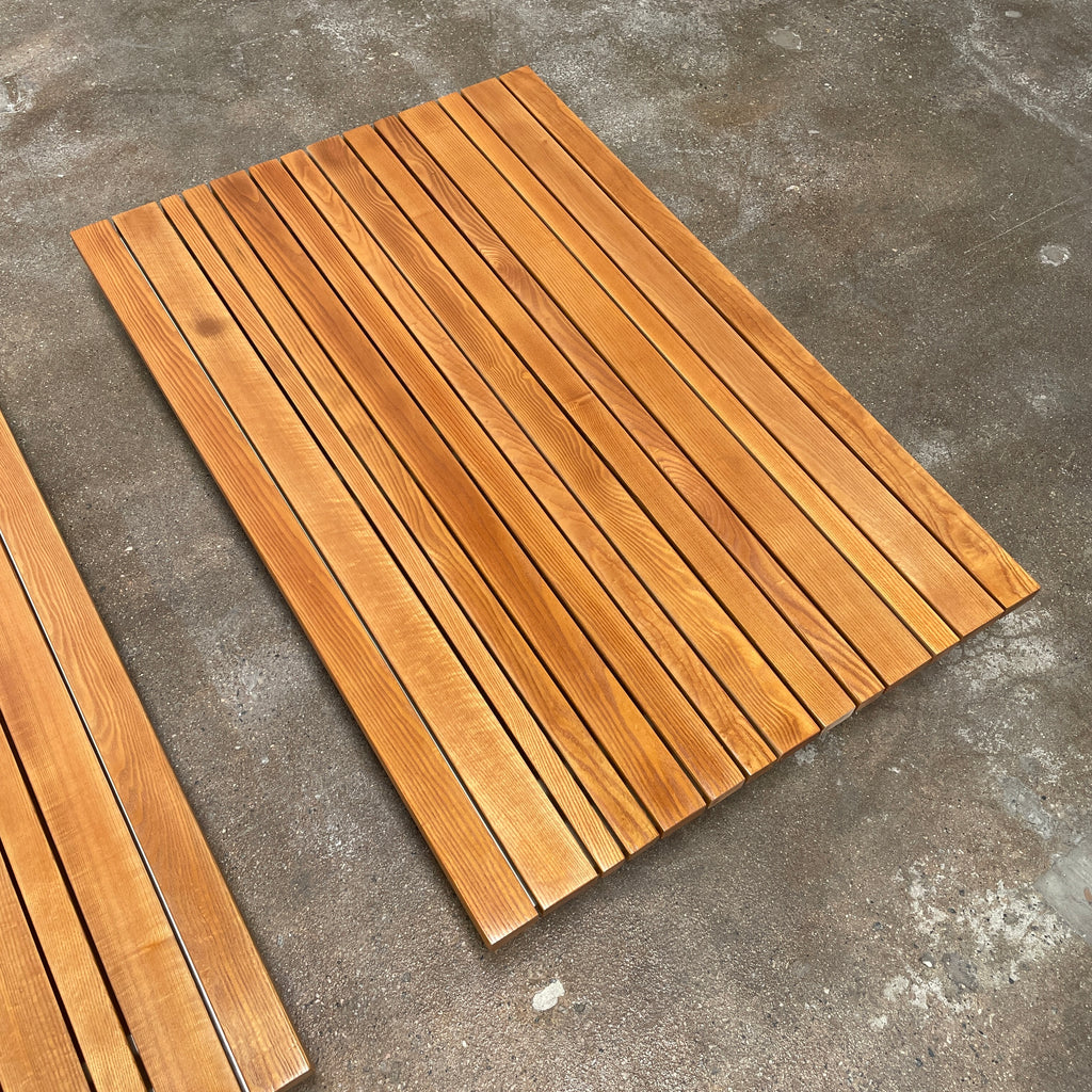 A simple wooden slatted platform on a white background, perfect for the Paola Lenti Sunset Outdoor Coffee Table.