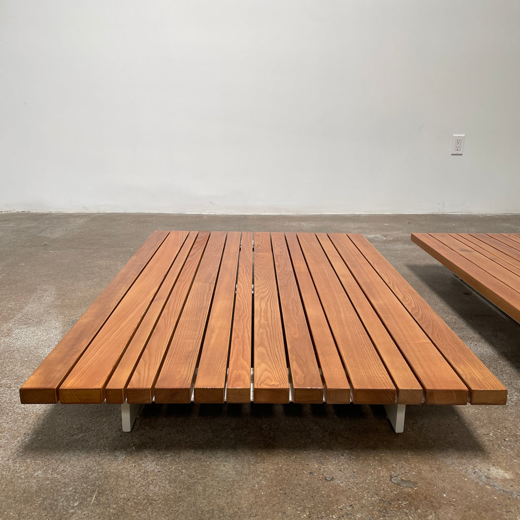 A simple wooden slatted platform on a white background, perfect for the Paola Lenti Sunset Outdoor Coffee Table.