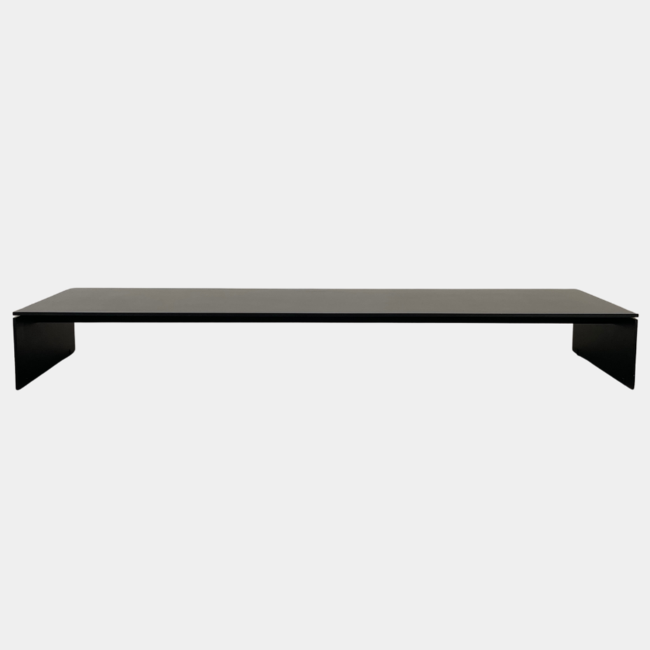 The Porro Modern Light Low Table by Piero Lissoni showcases a minimalist black design with a sleek metal structure and simple, rectangular legs, set against a plain background.