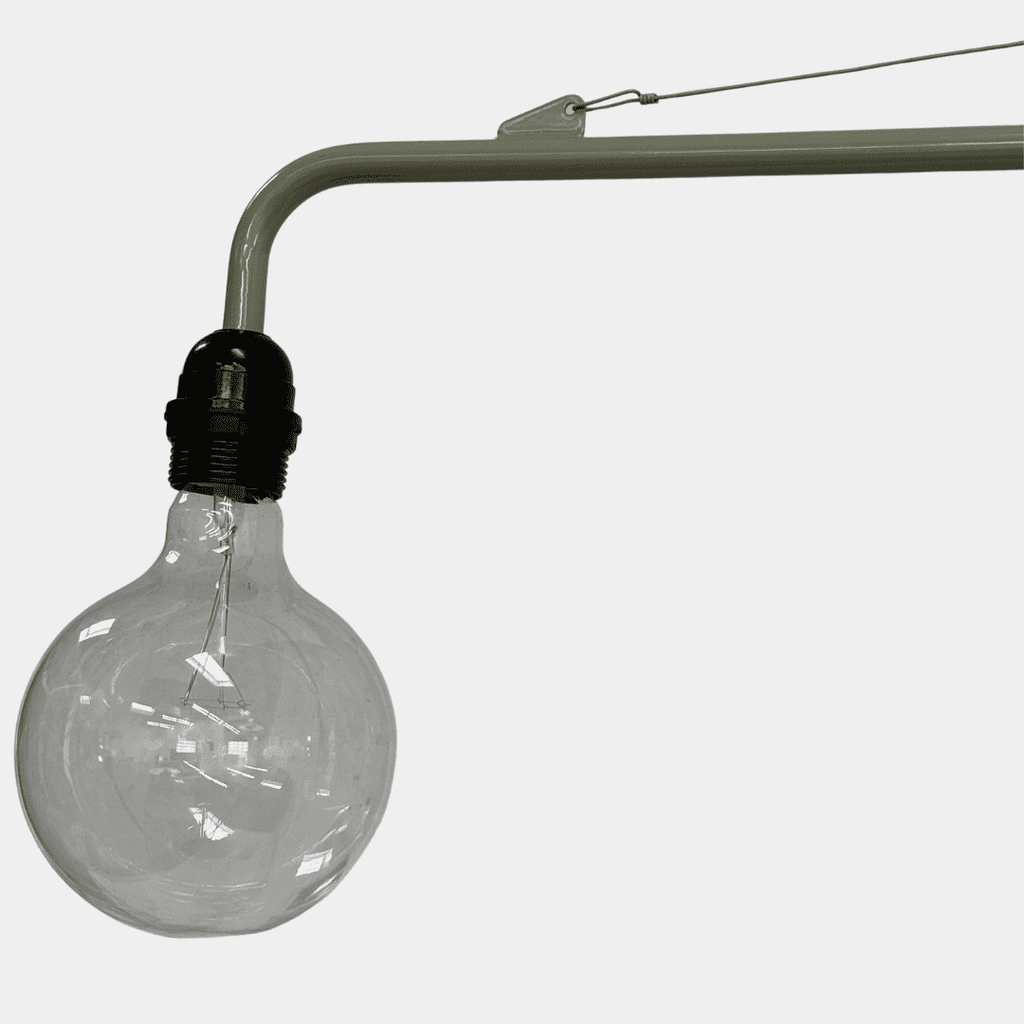 A wall-mounted swing arm sconce from Vitra, the Prouvé Petite Potence Swing Arm Sconce, features an exposed bulb with a sleek black cord hanging elegantly.