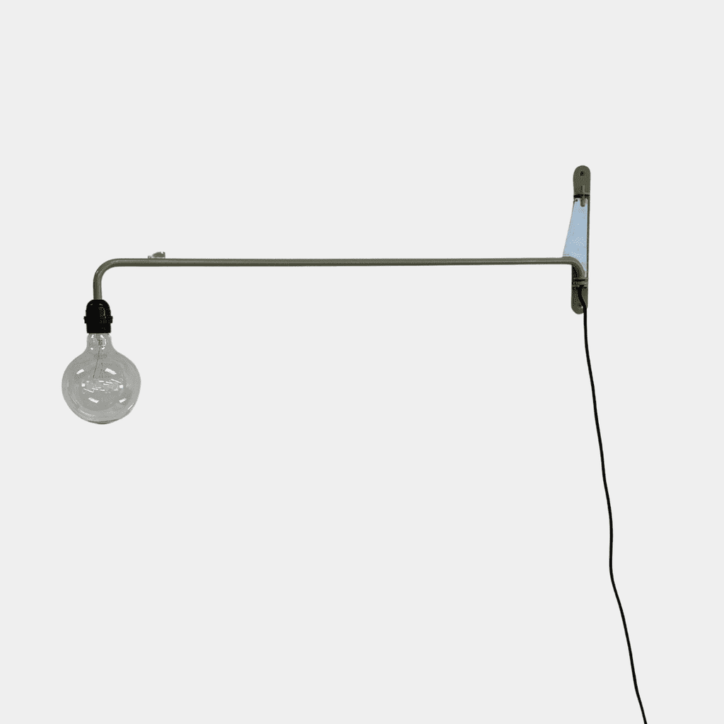 A wall-mounted swing arm sconce from Vitra, the Prouvé Petite Potence Swing Arm Sconce, features an exposed bulb with a sleek black cord hanging elegantly.