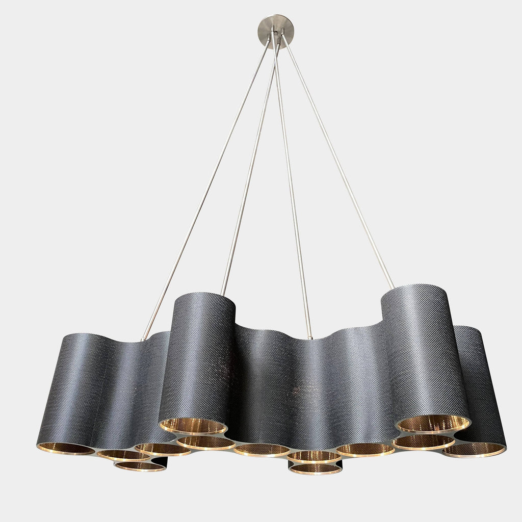 A modern metal chandelier with multiple cylindrical shades connected by thin, curved attachments, hanging from a ceiling mount—a design reminiscent of the Ralph Pucci Linear Cumulus Ceiling Light.