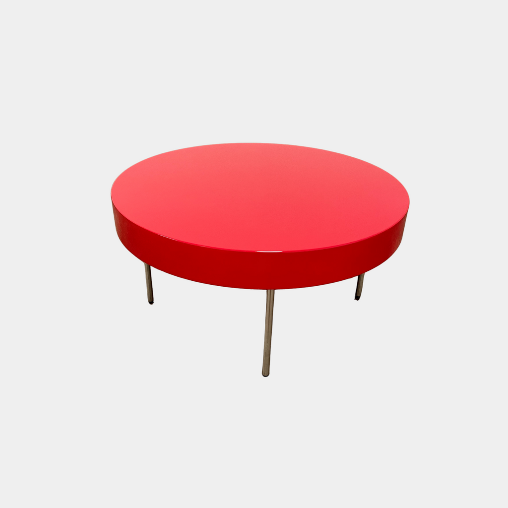 A Ligne Roset Red Lacquer Needle Table with a glossy red surface and four slim metal legs sits on a plain white background, capturing the essence of modern elegance characteristic of Ligne Roset designs.