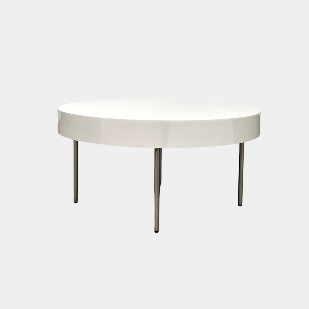 The Ligne Roset White Lacquer Needle Table features a sleek lacquer top and four slender metal legs, perfectly exemplifying modern minimalism against a plain background.