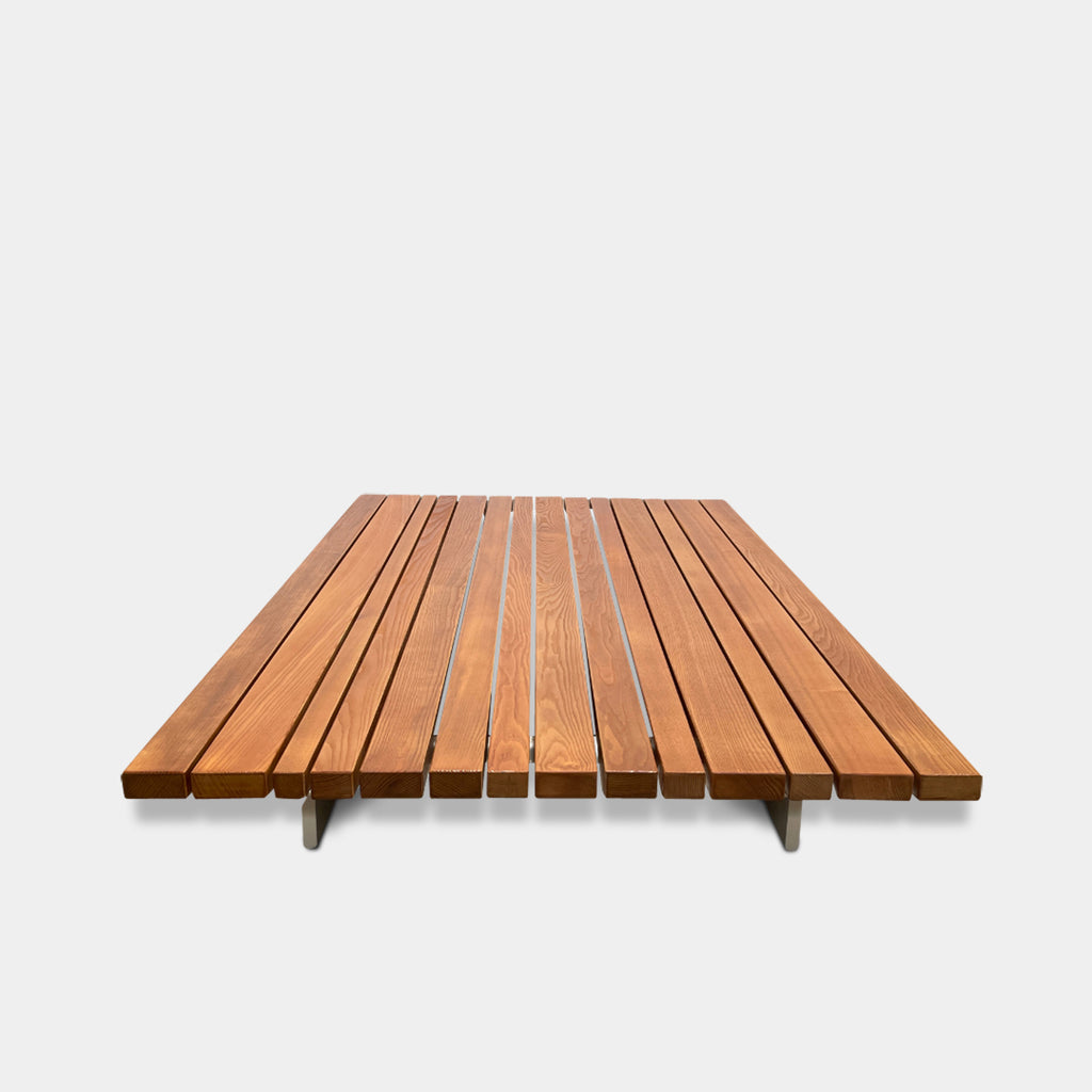 A simple wooden slatted platform on a white background, perfect for the Paola Lenti Sunset Outdoor Coffee Table.