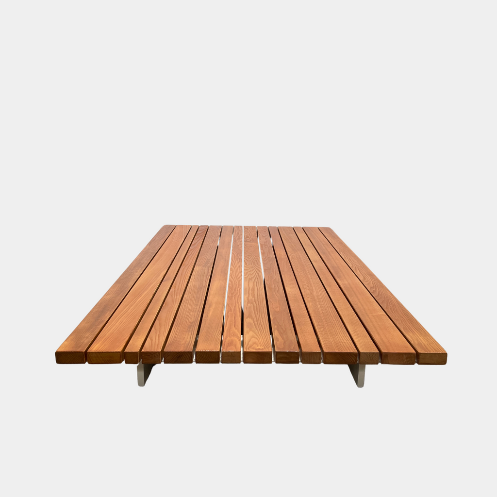 A simple wooden slatted platform on a white background, perfect for the Paola Lenti Sunset Outdoor Coffee Table.