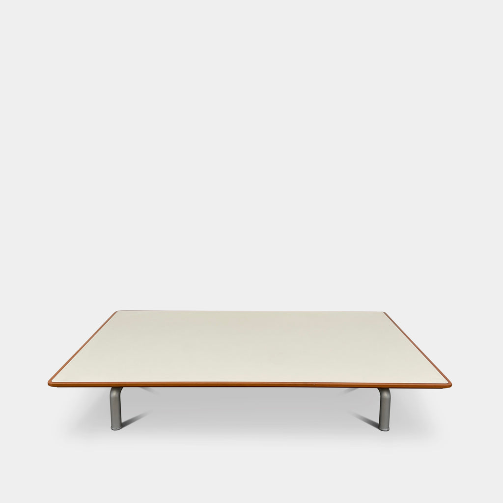 This modern design showcases a Vintage Ligne Roset Coffee Table that features a white lacquer top with thin edges, supported by four metal legs. It's an ideal centerpiece for contemporary living spaces, combining sophistication and simplicity.